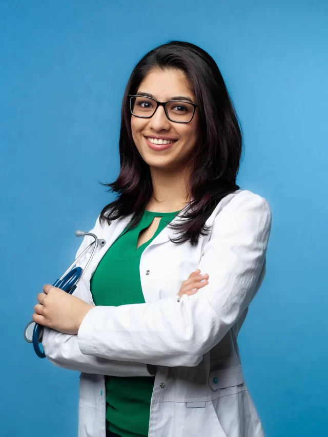 medical-concept-asian-beautiful-female-doctor-white-coat-with-glasses-waist-high-medical-student-female-hospital-worker-looks-into-camera-smiles-studio-blue-background